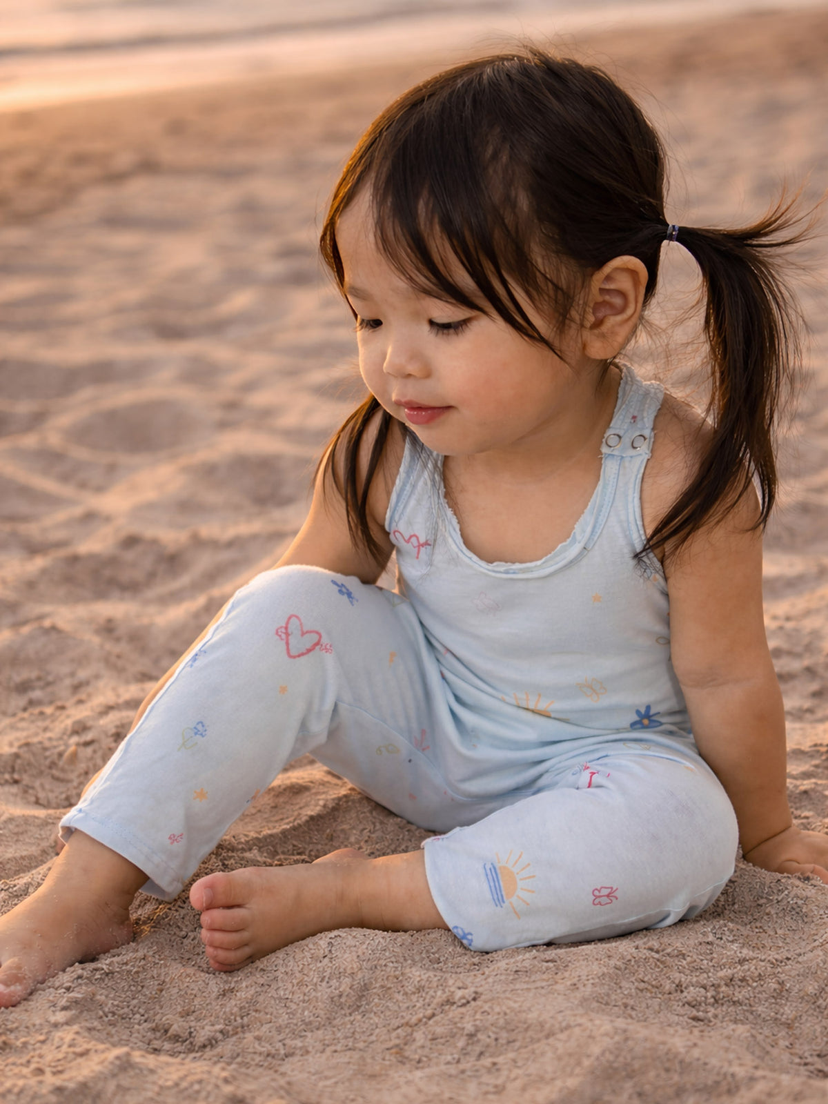 Light blue tank romper with colorful icon print and sleeveless crew neck