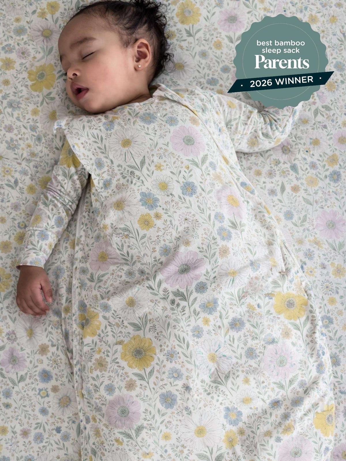 Infant wearing pastel wildflower sleep sack, side view with long sleeves and cuffed hands.