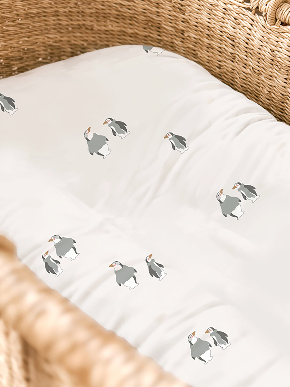 White changing pad cover with repeating gray penguin print