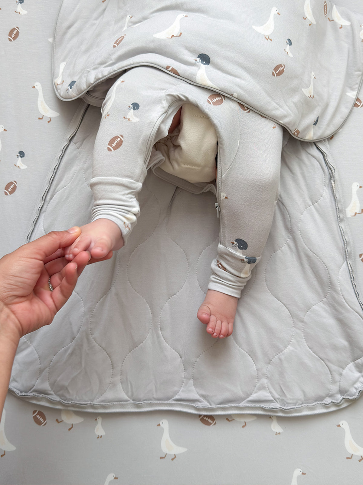 Long-sleeve sleep sack with foot openings, light gray goose and football print, zip front