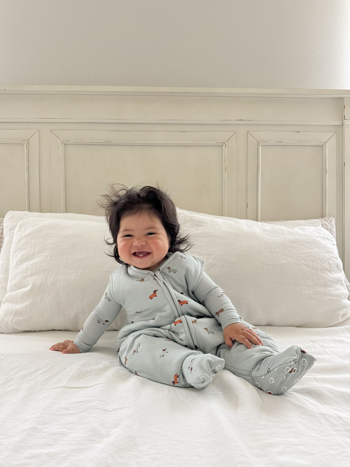 Light blue dog-print footie sleep sack on toddler, front zip and full-length legs