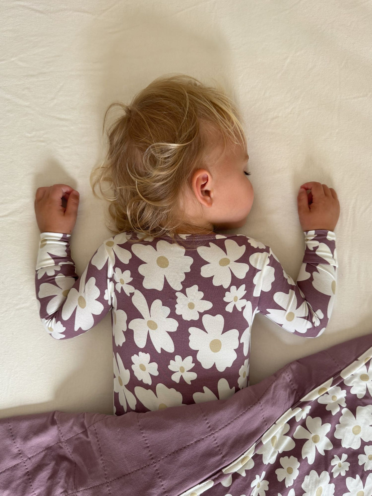 Maroon floral convertible pajamas with cream flowers; long sleeves and footed legs, back view