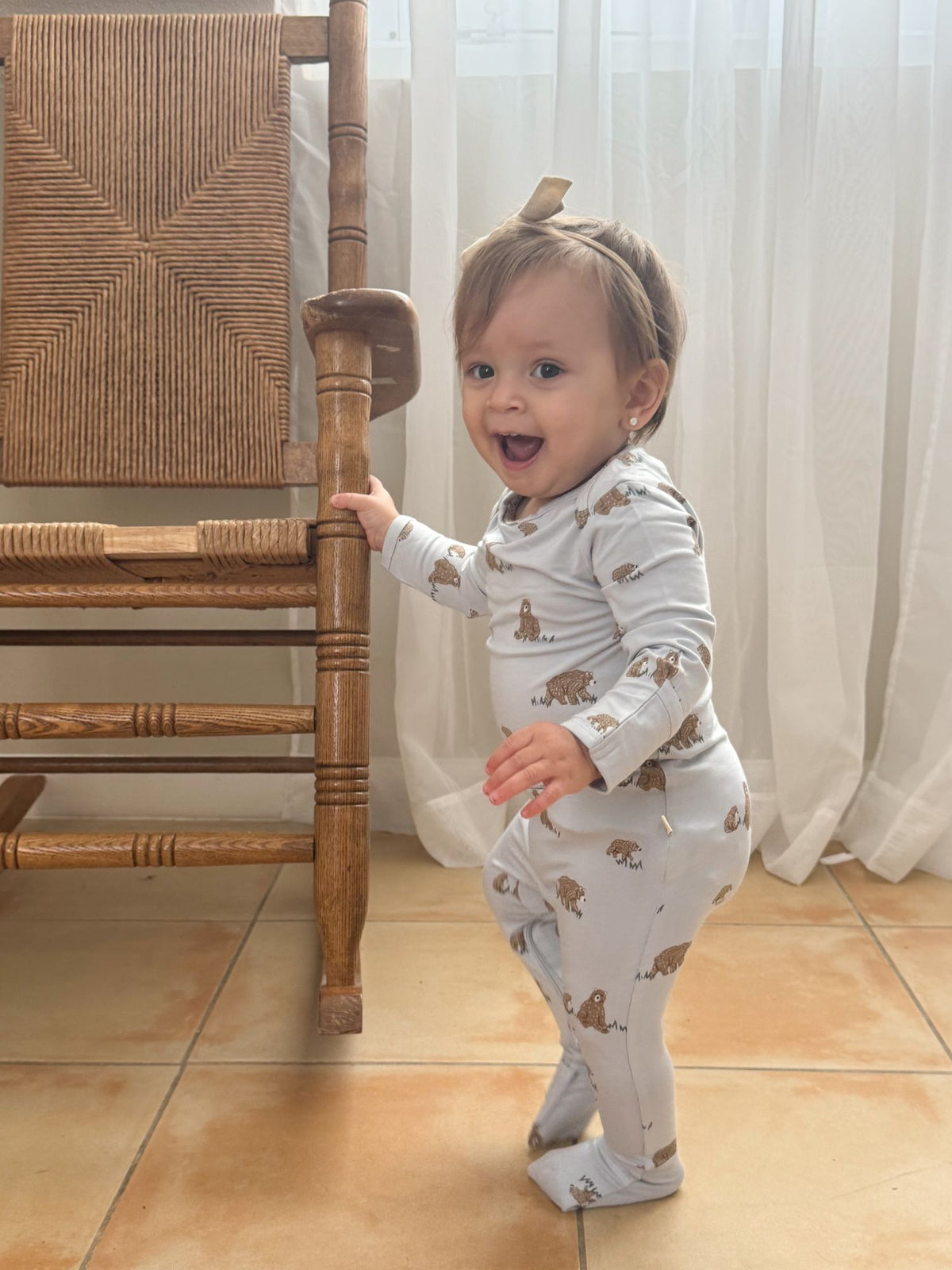 Teddy-printed convertible pajama on baby standing, long sleeves and foot covers