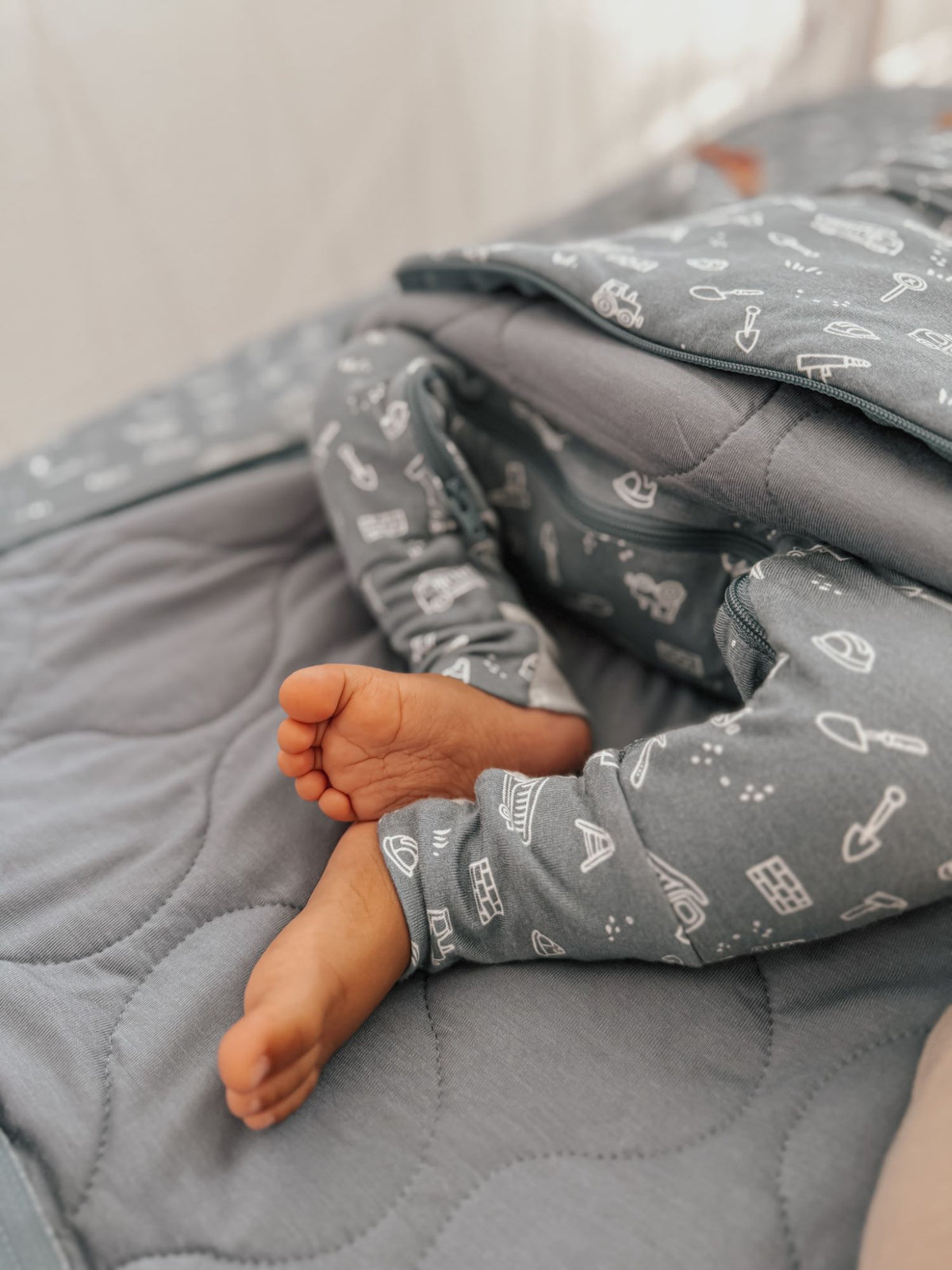 Blue-gray swaddle sack close-up, long sleeves with white icon print