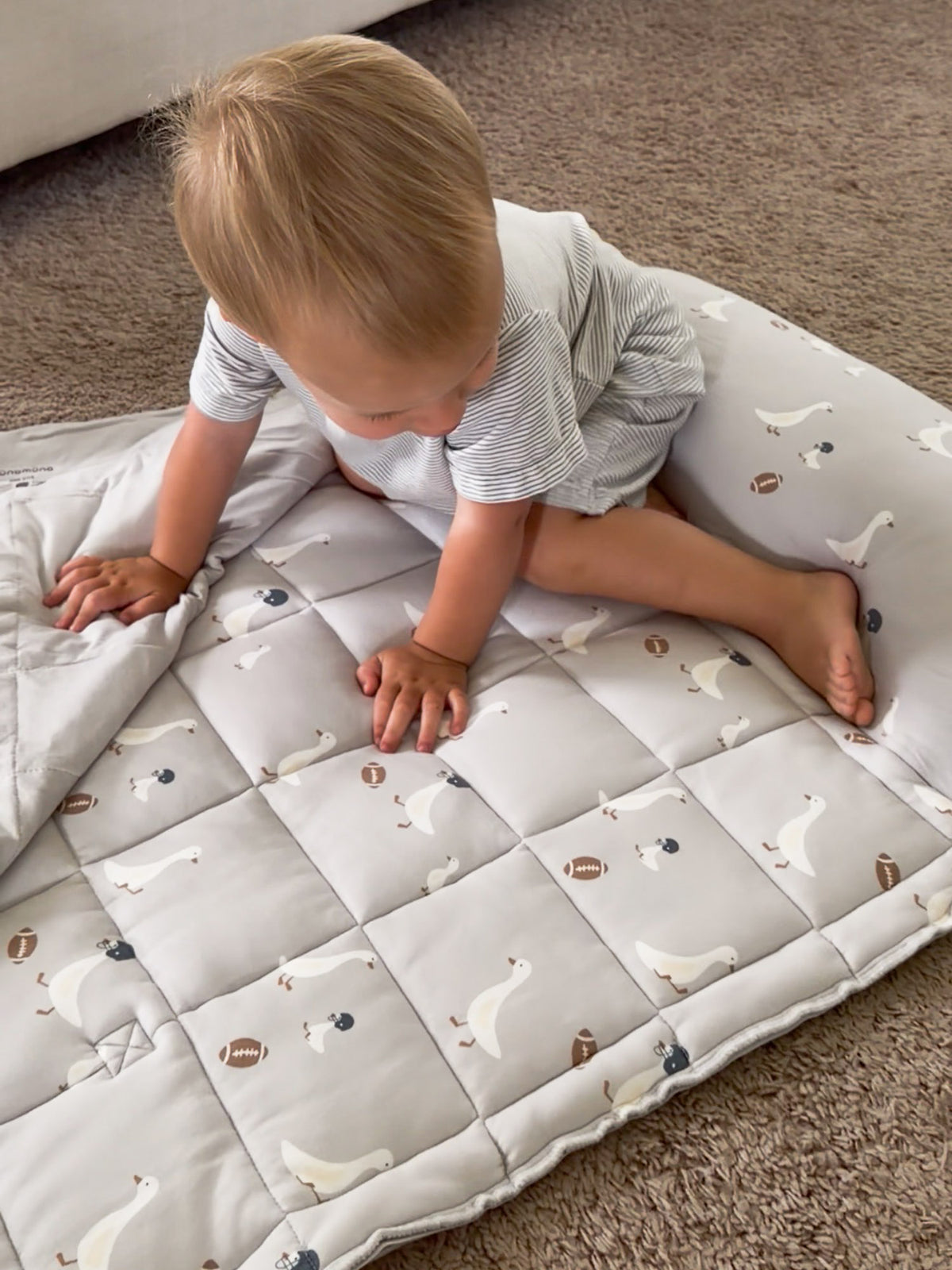Quilted gray nap mat with repeating goose and football prints and fold-over cover