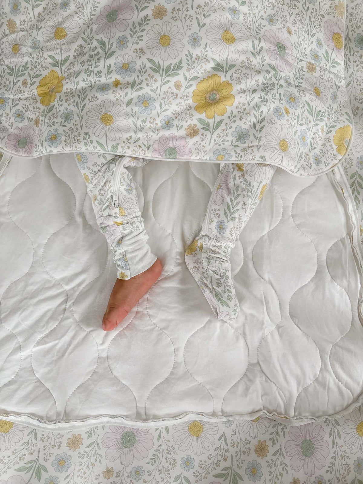 White floral sleep sack with long sleeves and fold-over mitt cuffs, open bottom