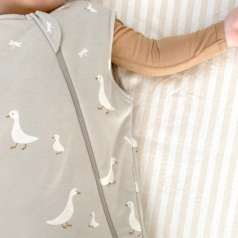 Light gray sleep sack fabric with white duck pattern and visible front zipper detail