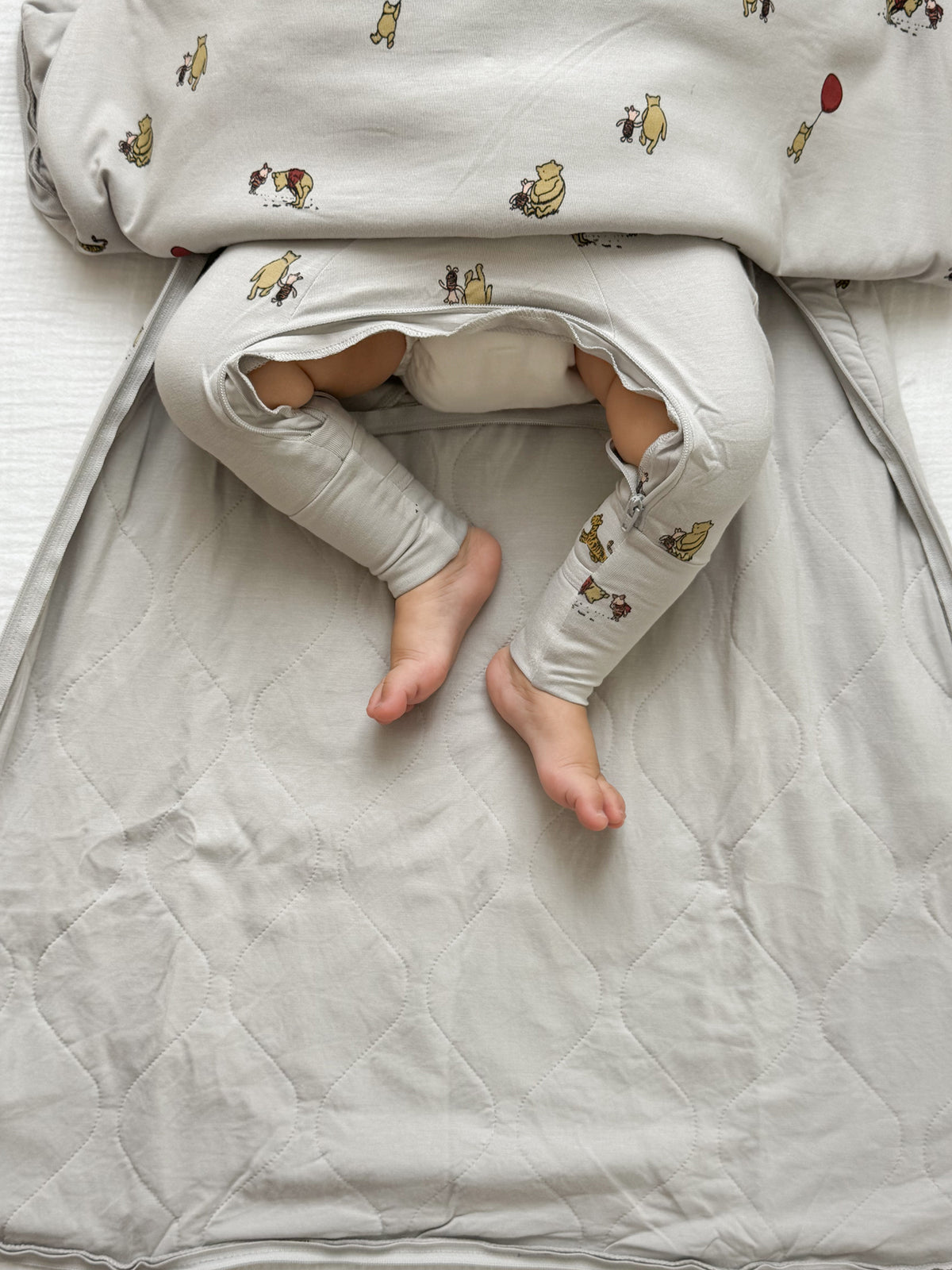 White baby sleep sack with Pooh character prints and arm openings