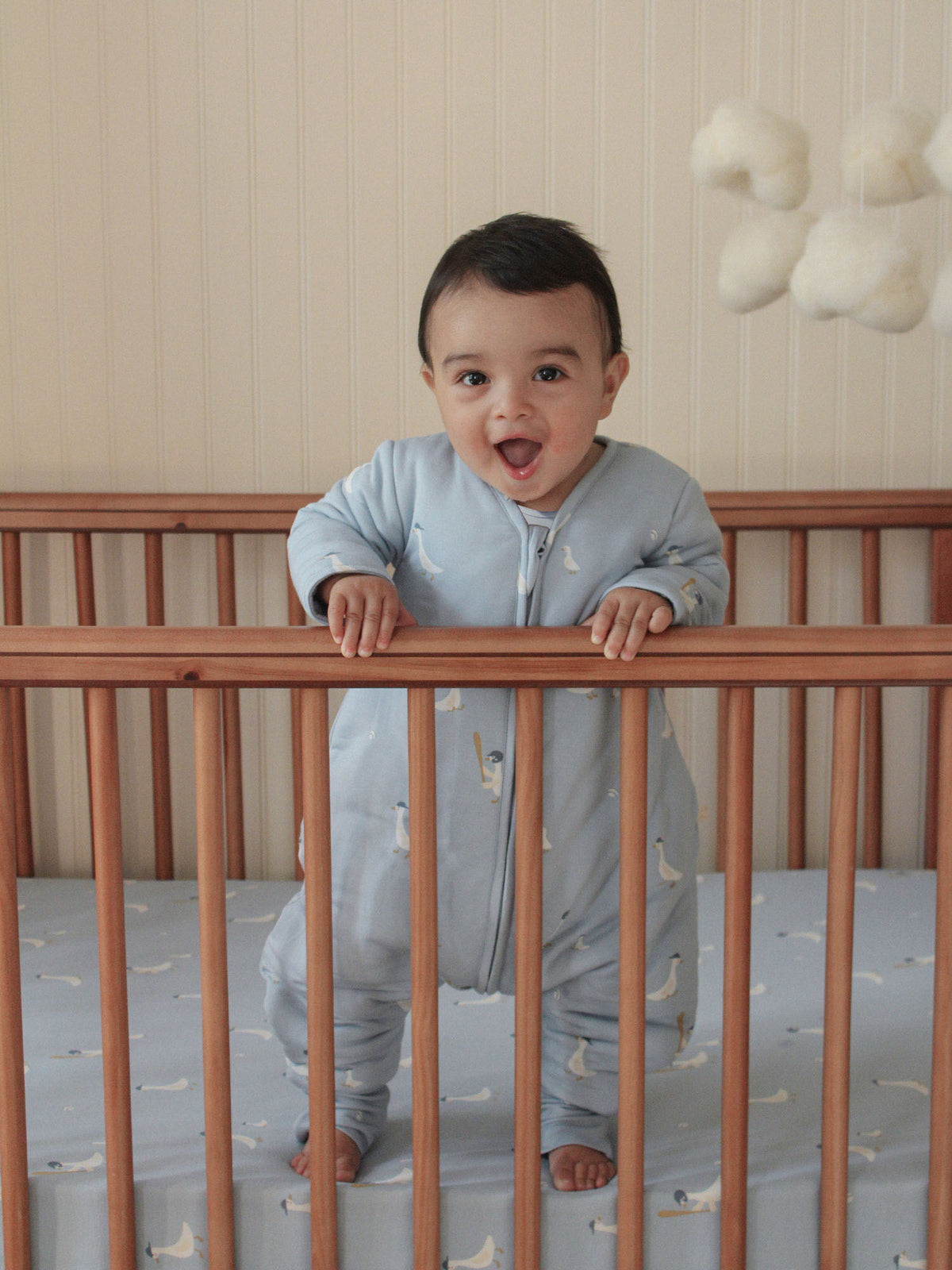 Light blue footie sleep sack with long sleeves, front zipper, and small bird print