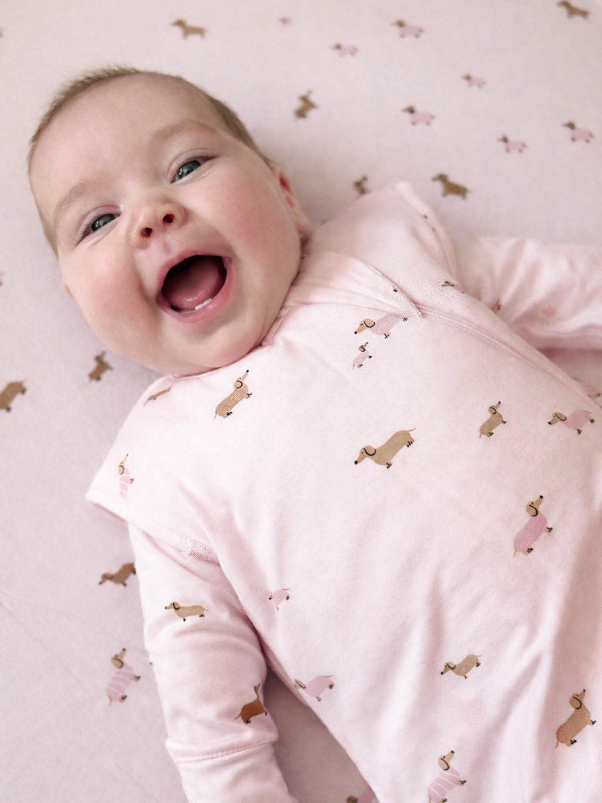Light pink dog-print sleep sack with round neckline and front zipper, long sleeves
