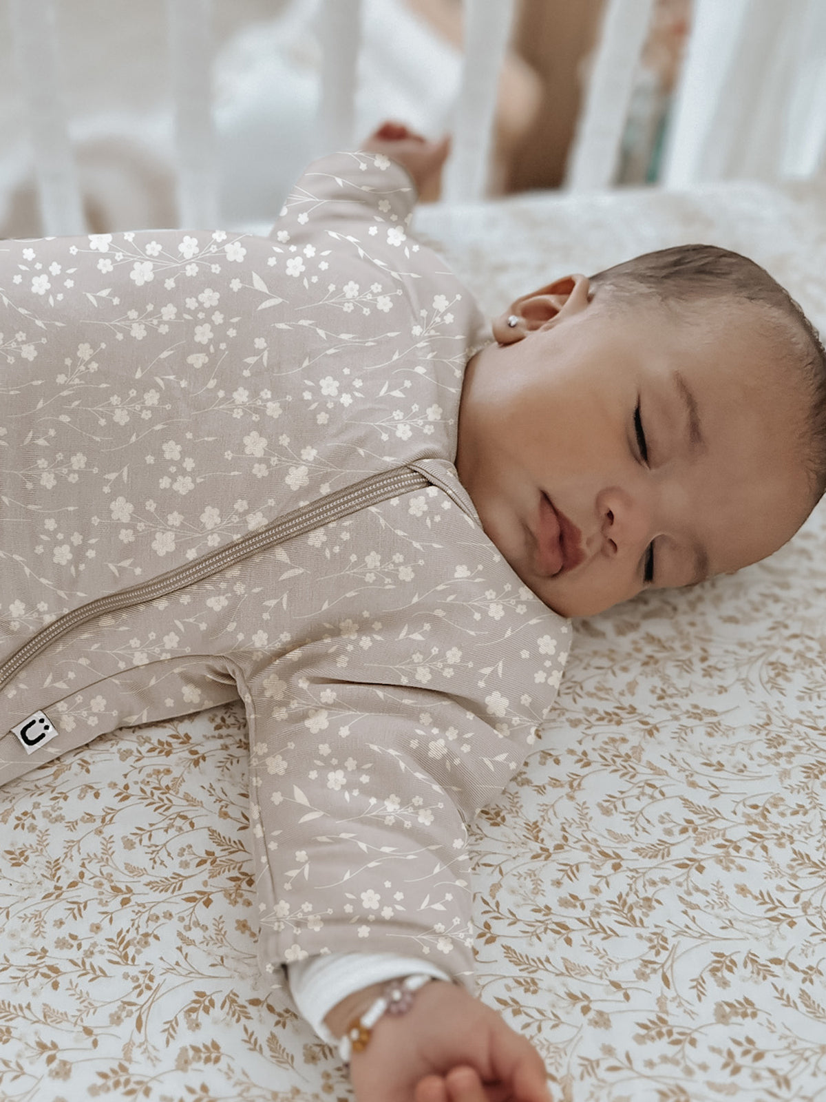 Long sleeve swaddle sack in beige with small white floral print, zipper front