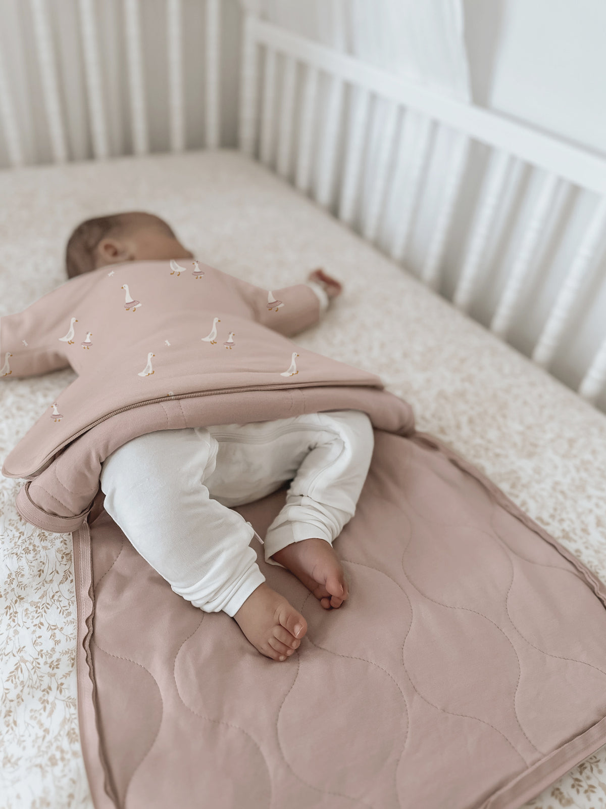 Long sleeve transitional swaddle sack in dusty pink with white goose print