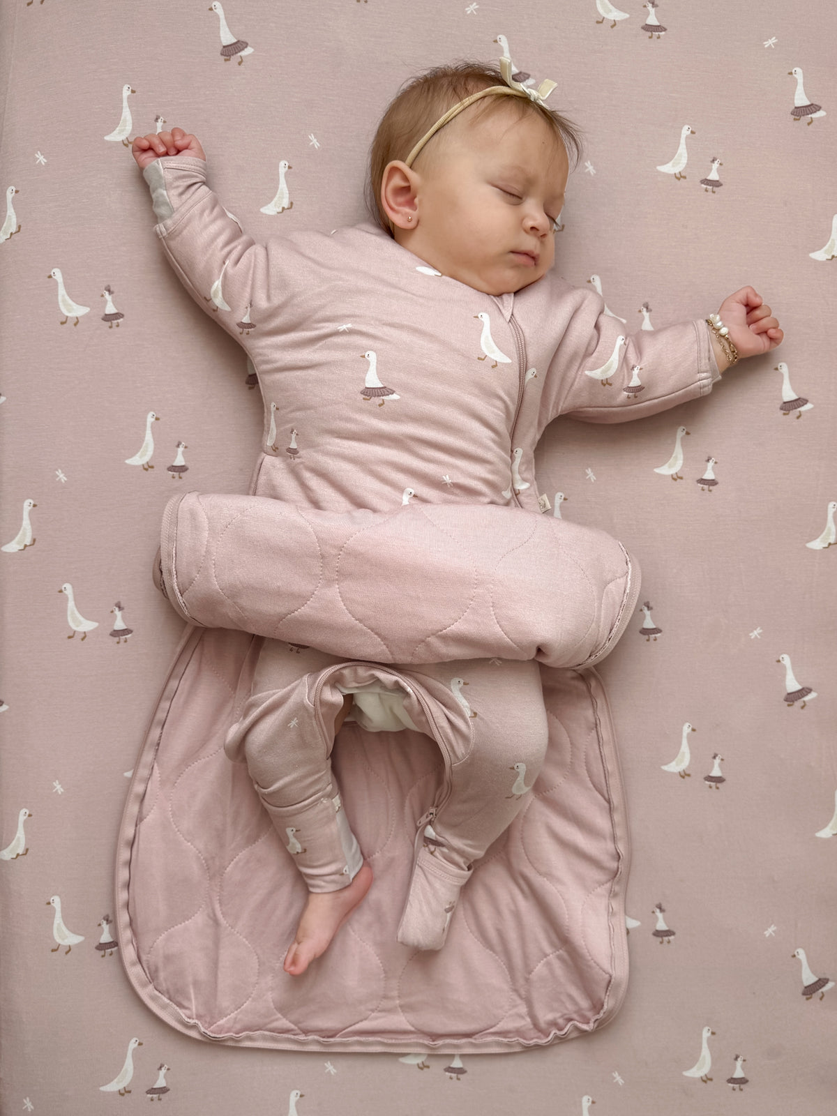 Long sleeve swaddle sack with wraparound design, dusty pink and white goose print