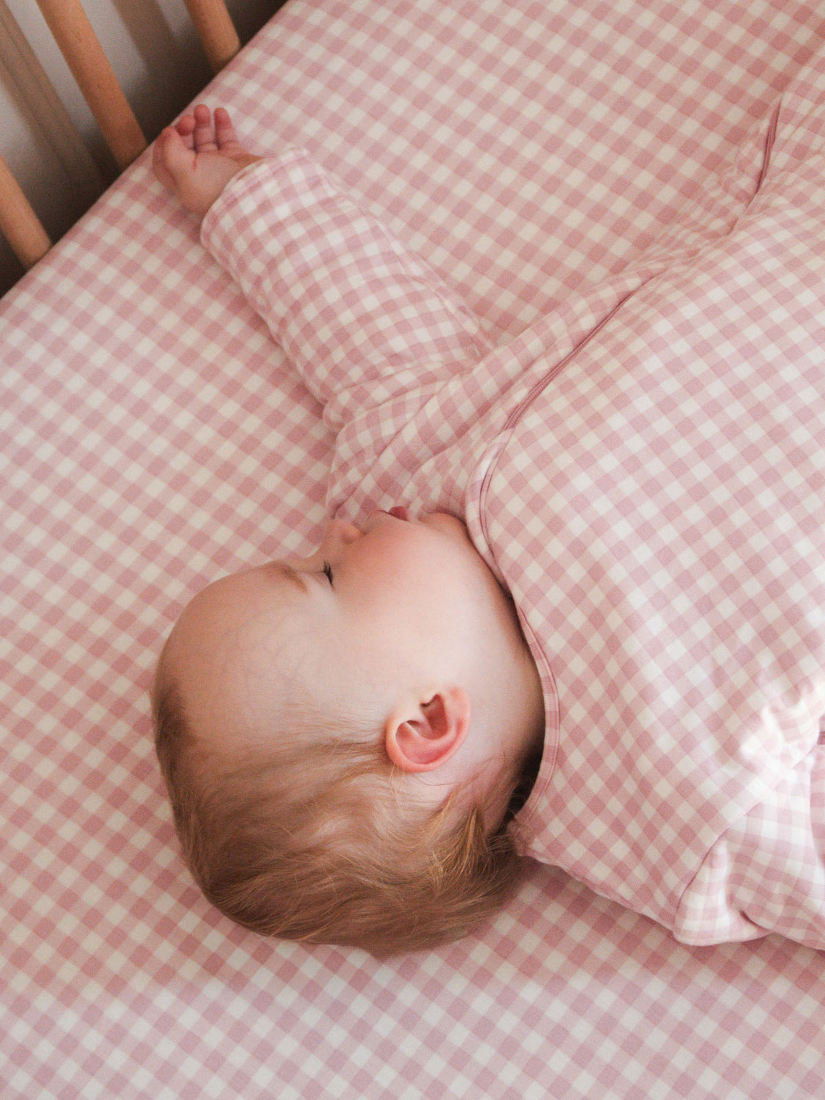 Pink gingham long-sleeve sleep sack with two-way zipper, lying flat
