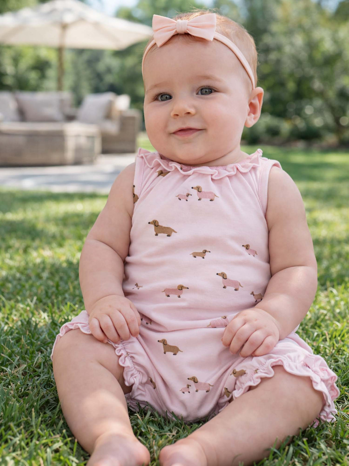 Girls' pink dog-print bubble romper with ruffled neckline and bow at top