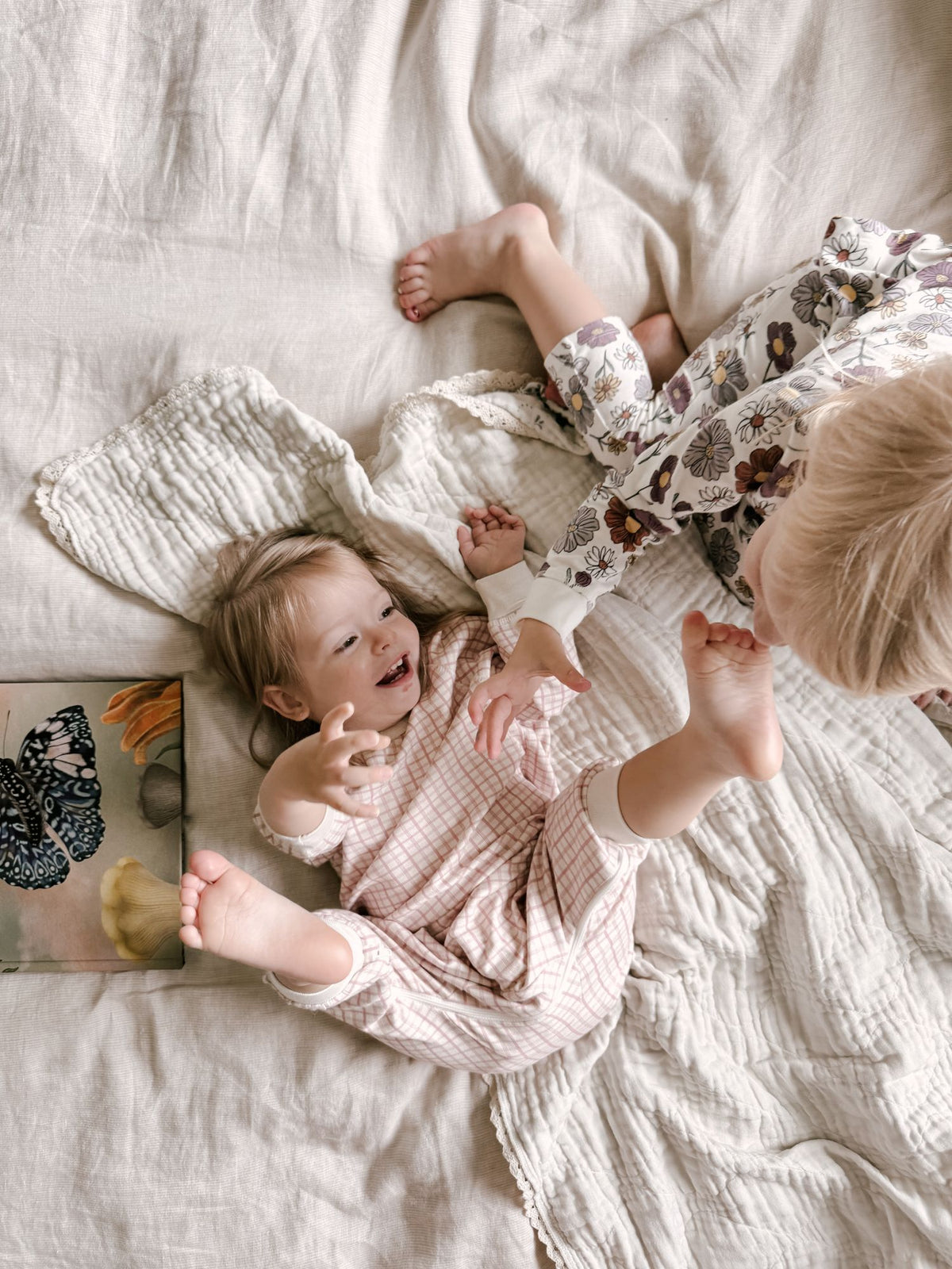 Light pink fleece jumpsuit with white cuffs and ruffled legs, long-sleeve footed design