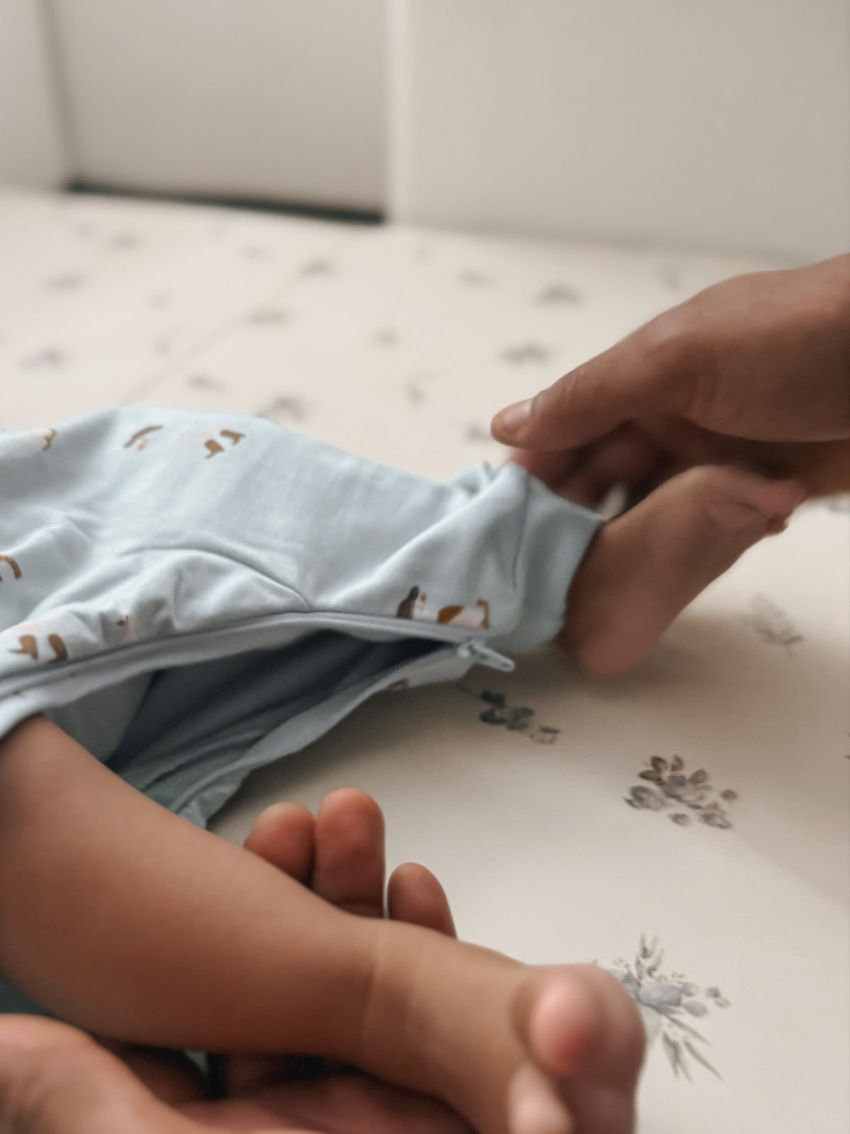 Light blue fleece jumpsuit with long sleeves and animal print, front opening visible