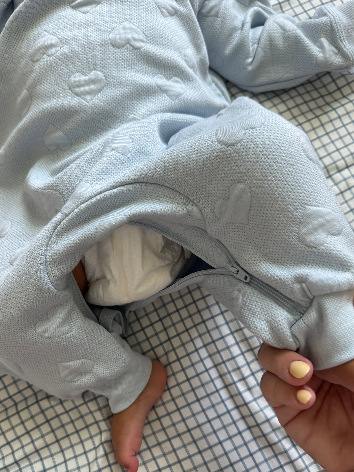 Light blue-gray footed jumpsuit with star-like appliques and zipper opening