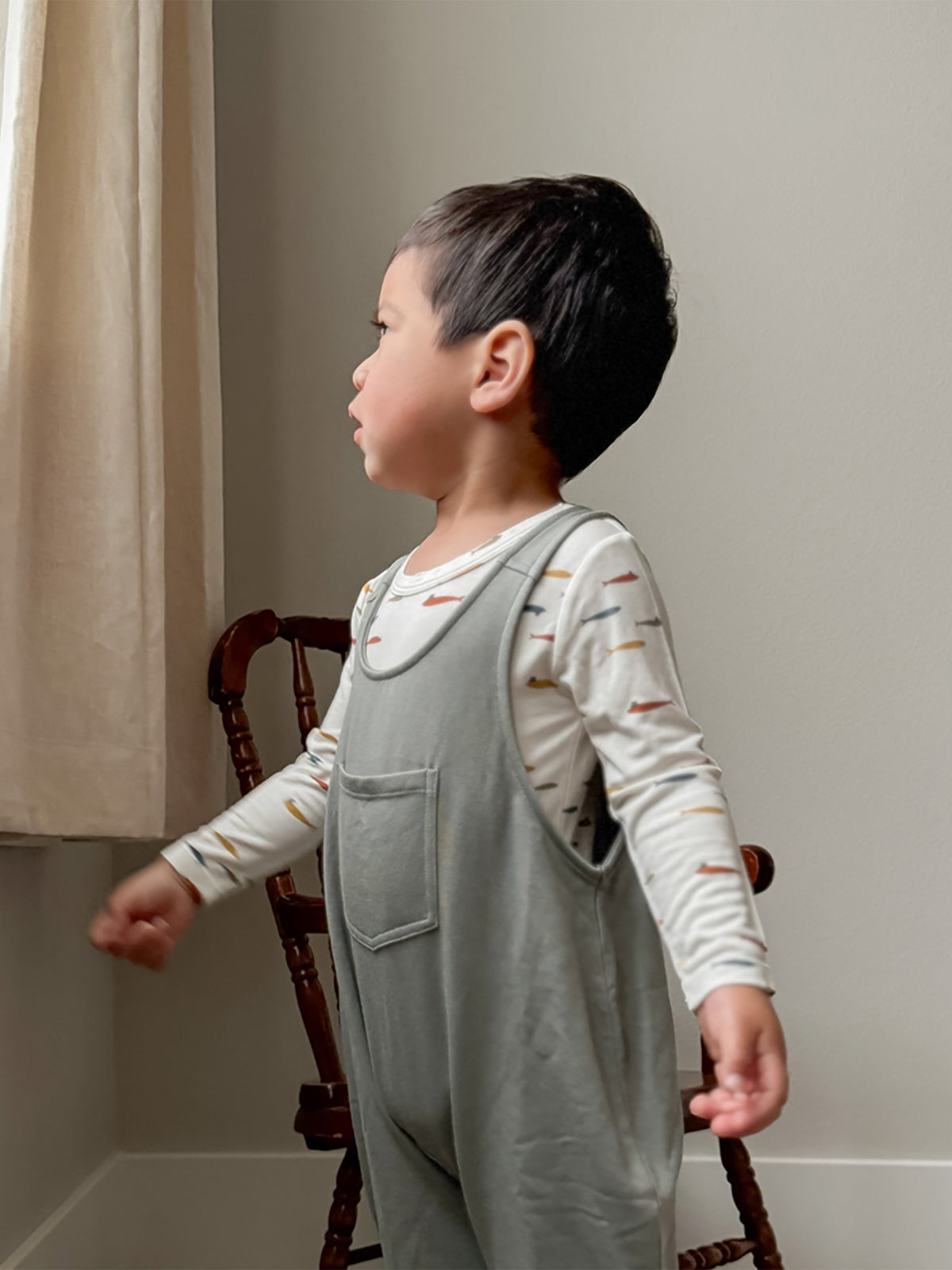 Light gray fleece overall set with front pocket, child standing in profile