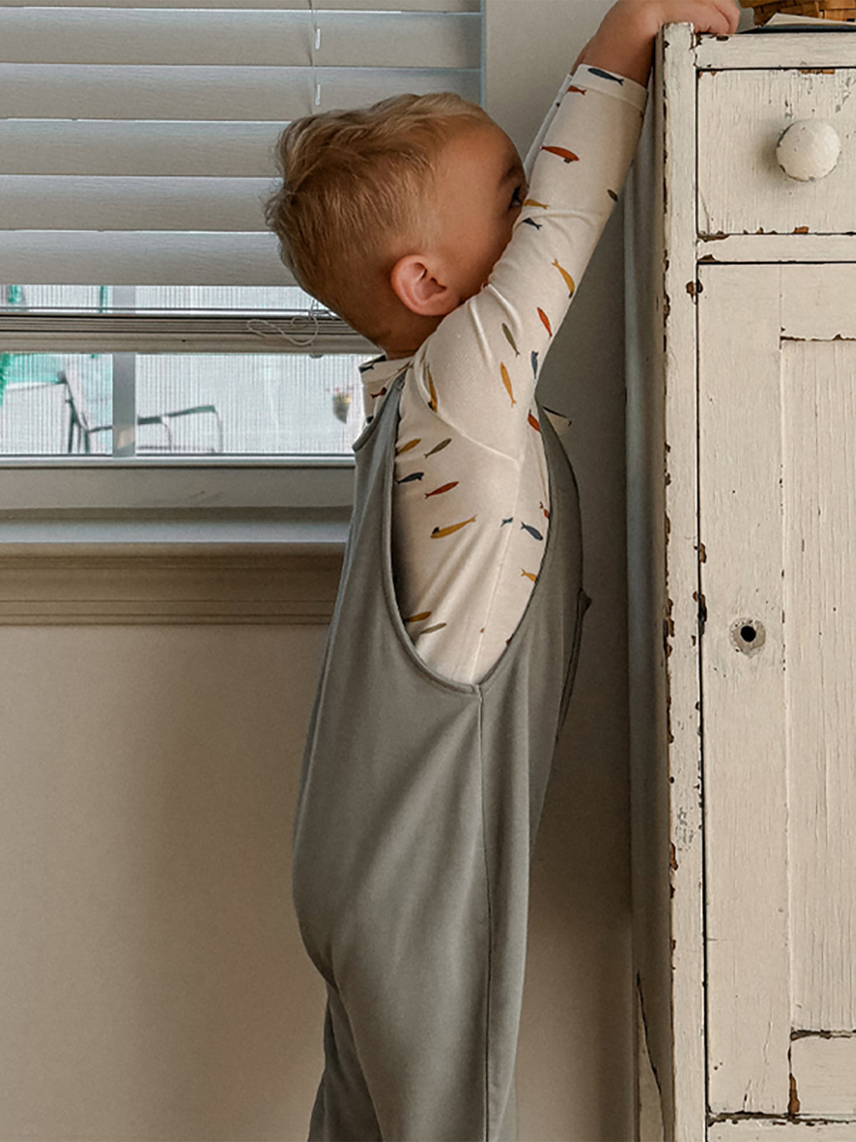 Light gray fleece overall set with side pocket, back view on child