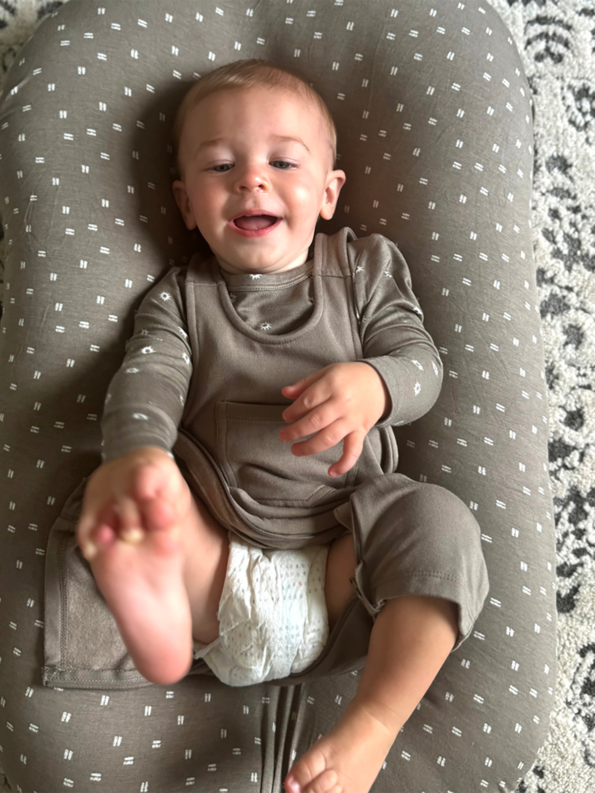 Taupe fleece overall romper with white dot print, front view while seated