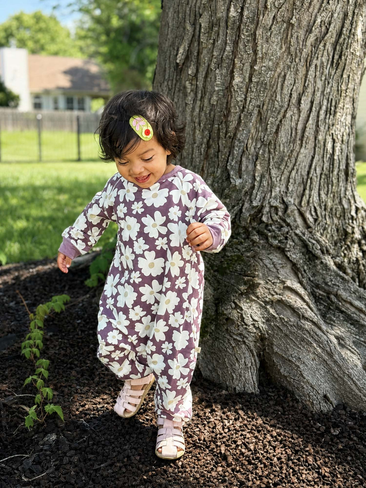 Purple fleece jumpsuit with white daisy print, long sleeves, footed full-body view