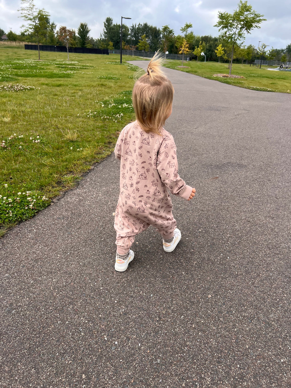 Light pink fleece jumpsuit with allover print, long sleeves and cuffed ankles