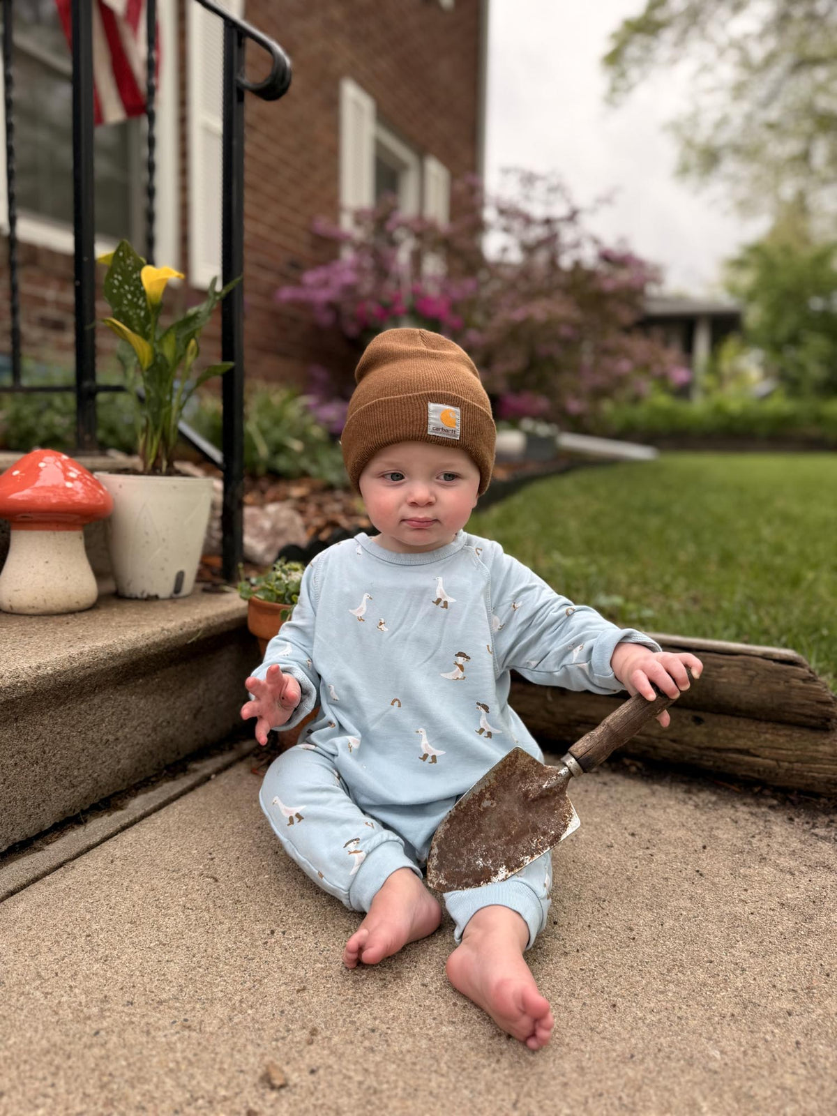 Light blue fleece jumpsuit with animal print, baby sitting wearing the outfit