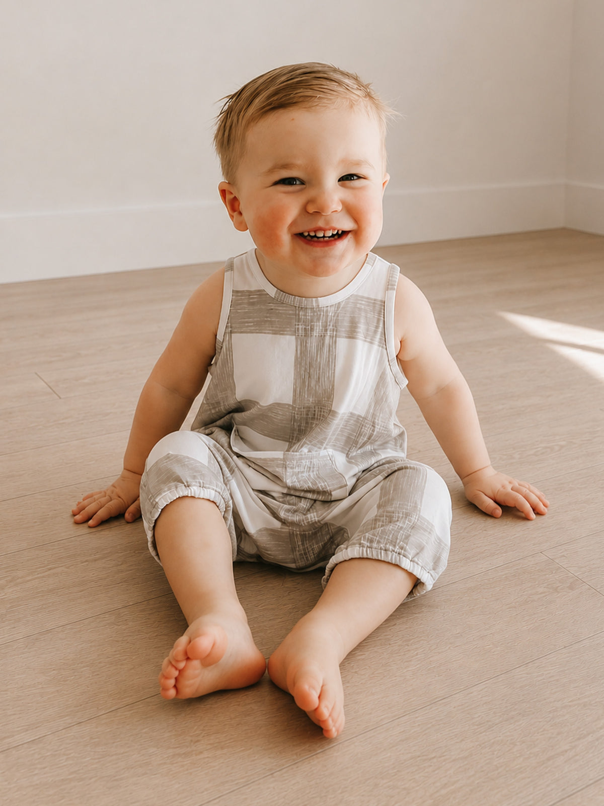 Sleeveless pocket romper in light gray and white with patchwork stripe pattern