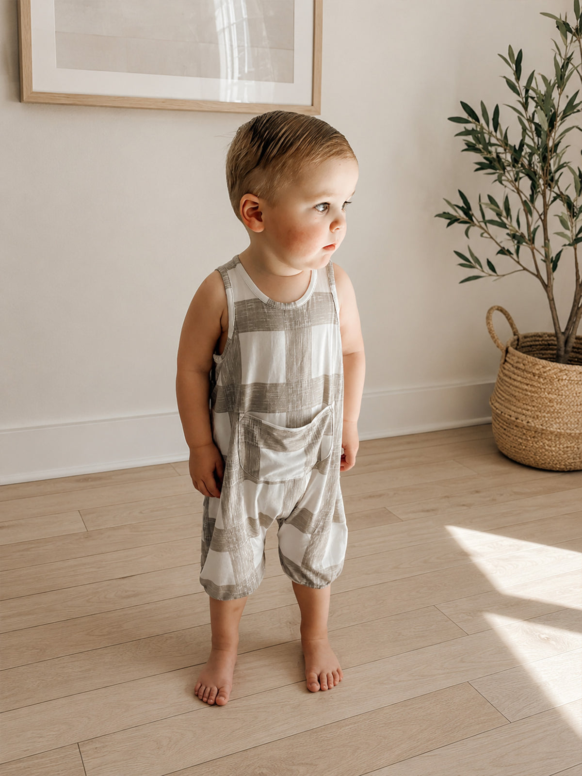Sleeveless pocket romper, light gray and white stripe pattern; toddler standing