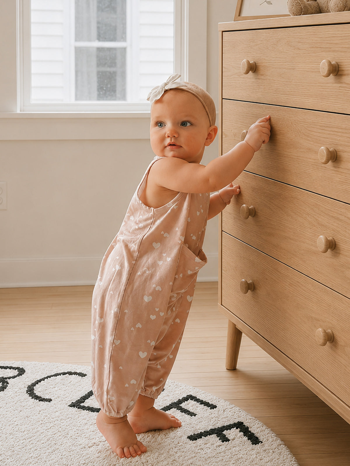 Light pink heart-print romper with sleeveless design and ruffled shoulder neckline