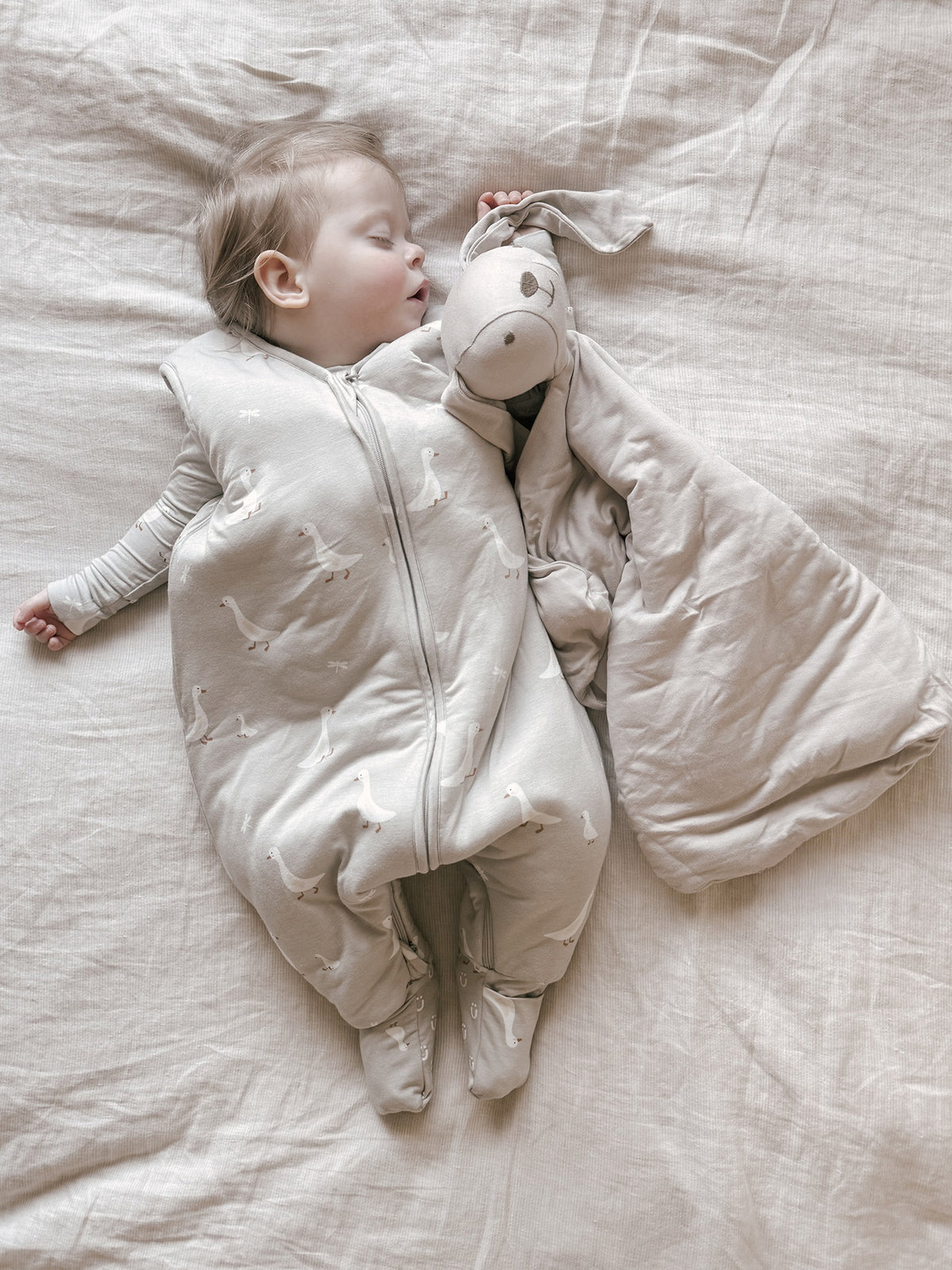 Light beige footie sleep sack with goose print, full-body zipper and built-in feet