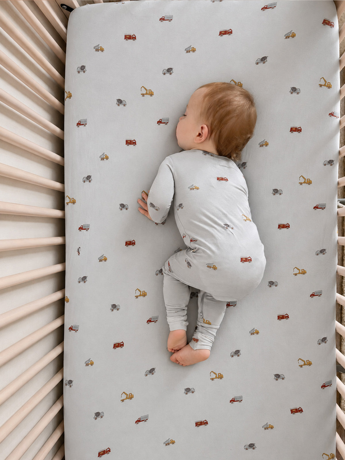 Light gray convertible pajama suit with allover toy vehicle print, long sleeves and legs