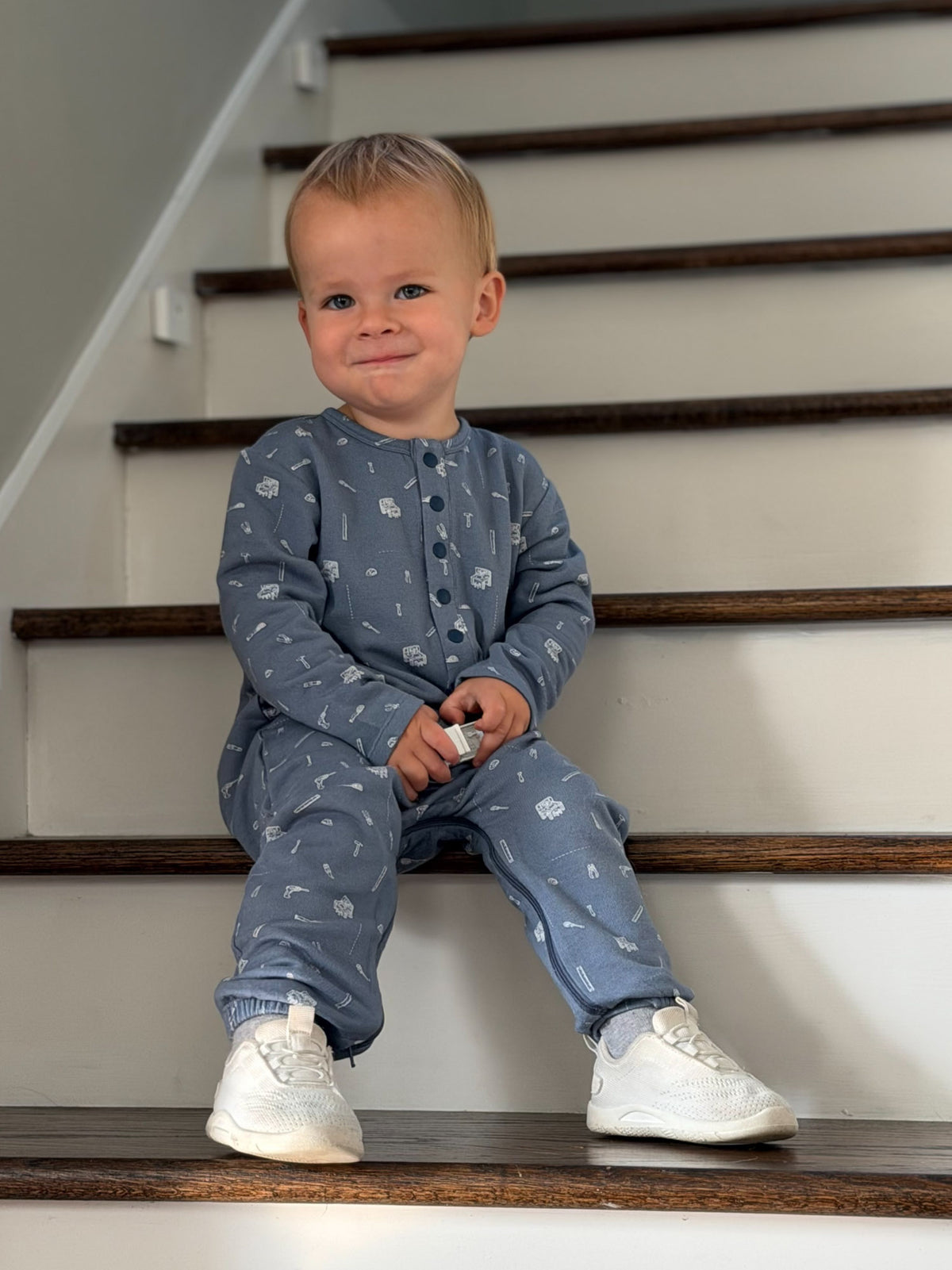 Blue tool-print henley jumpsuit with long sleeves and button-front