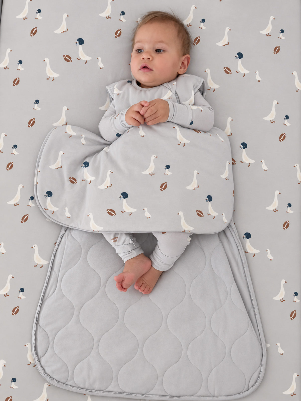 Light gray wearable sleep sack with goose-and-football print and padded bottom