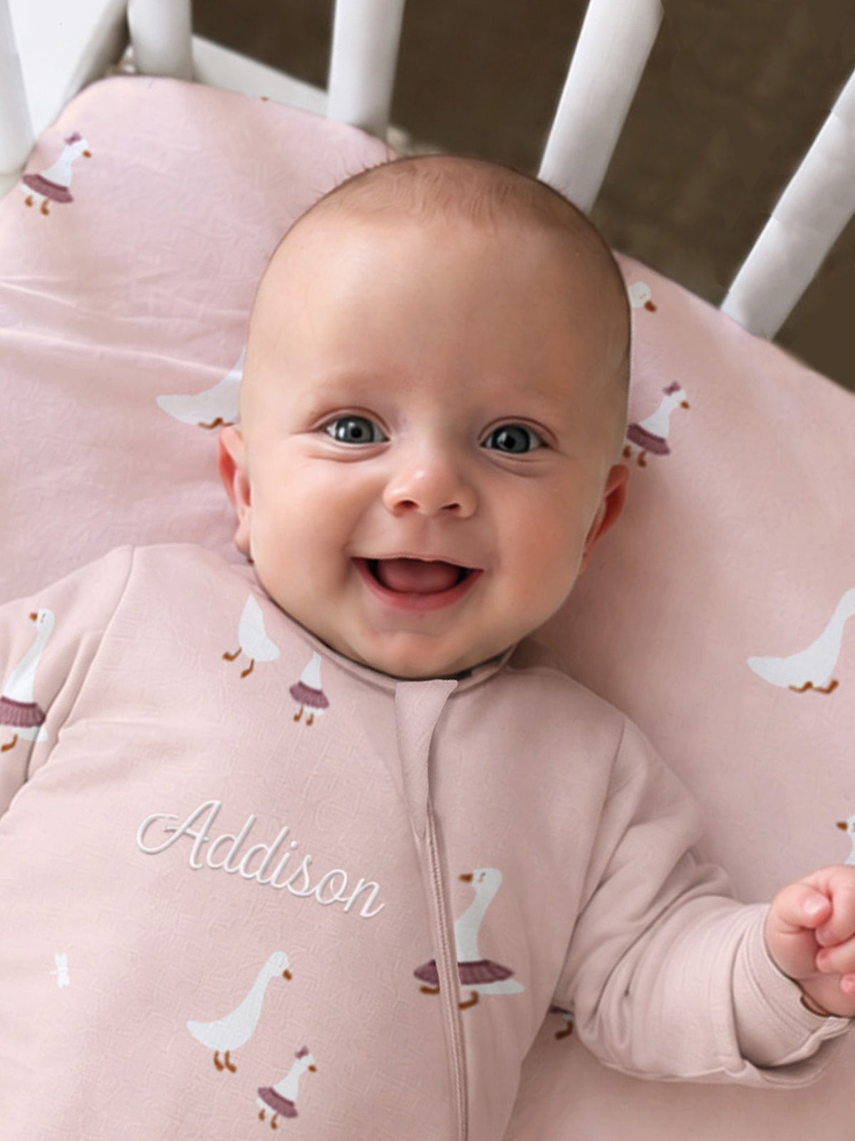 Pink long-sleeve sleep sack with duck print and zip-front opening, name text visible