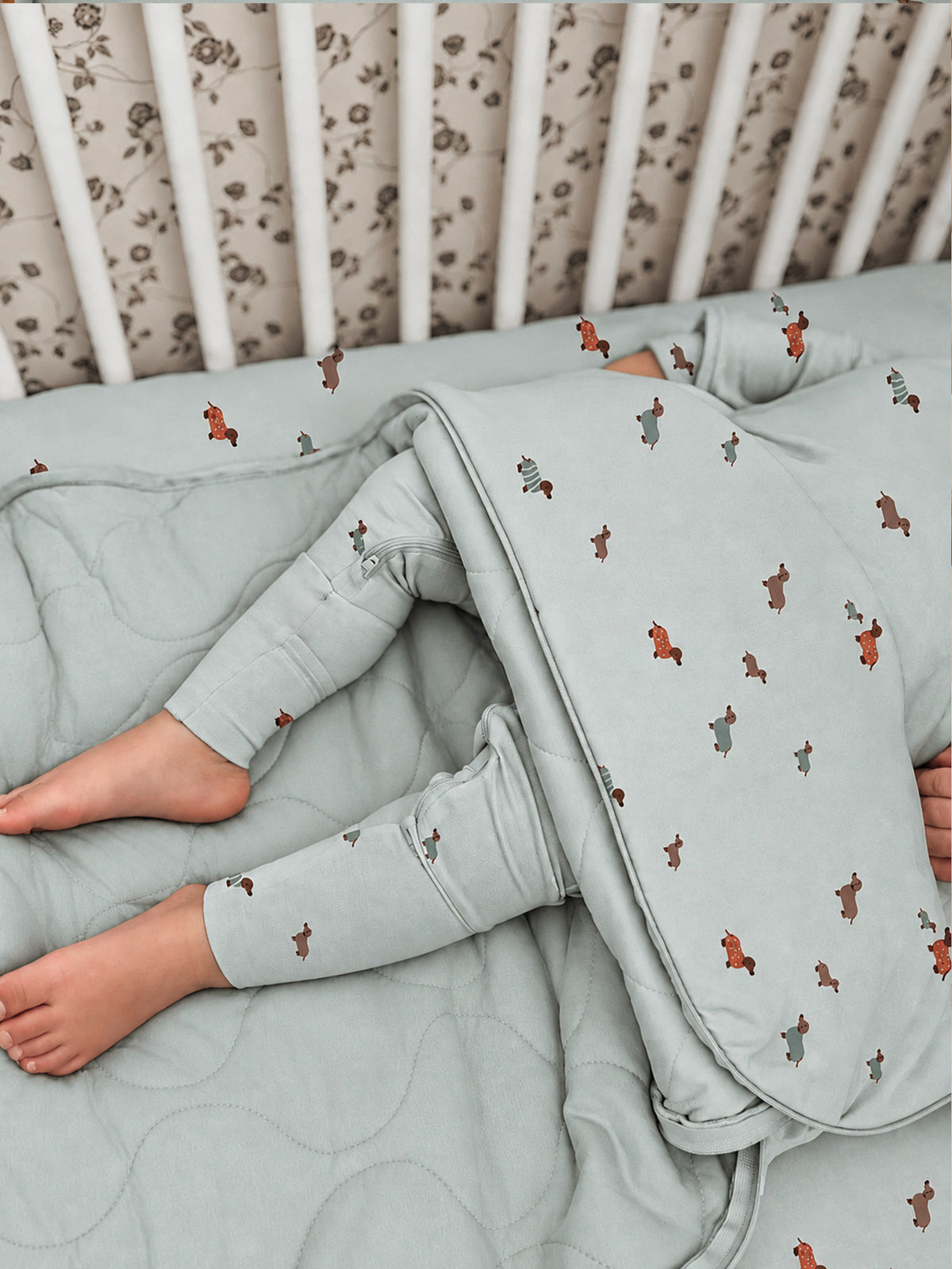Light blue long-sleeve sleep sack with orange dog prints, folded with sleeves.