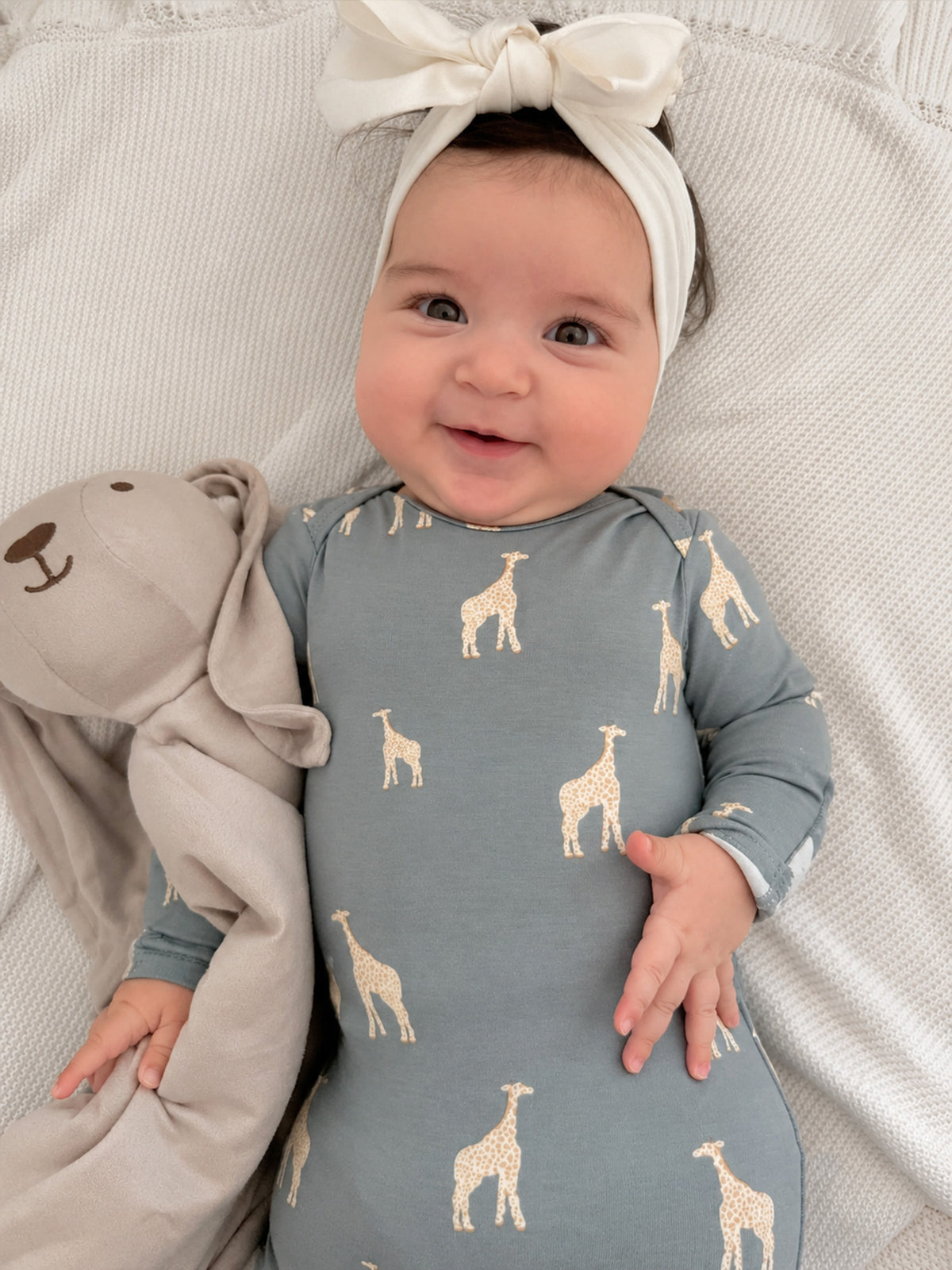Blue-gray baby romper with long sleeves and beige giraffe print, bow headband