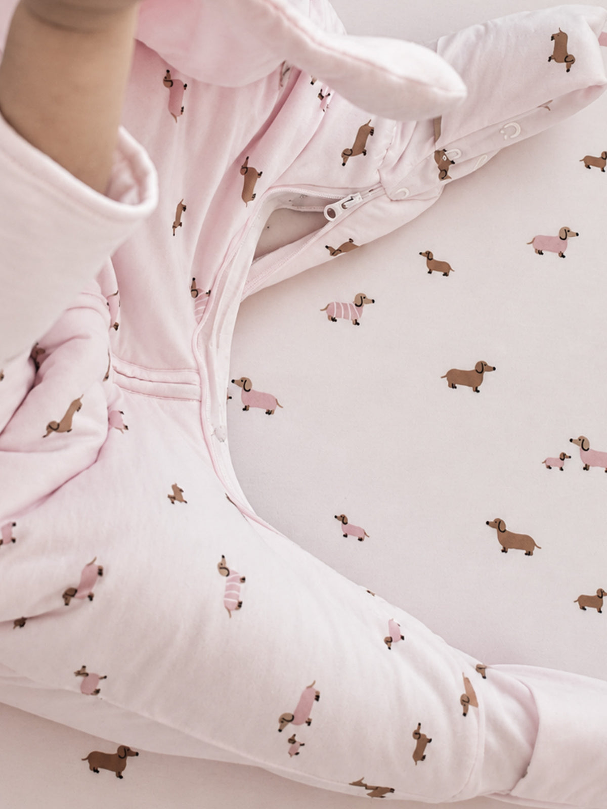 Pink dog-print sleep sack with long-sleeve cuffs and front zipper detail