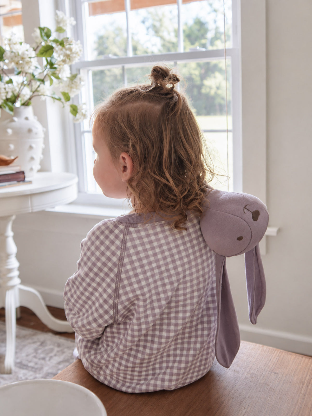 Lavender bunny lovey plush on a toddler’s shoulder with long ears