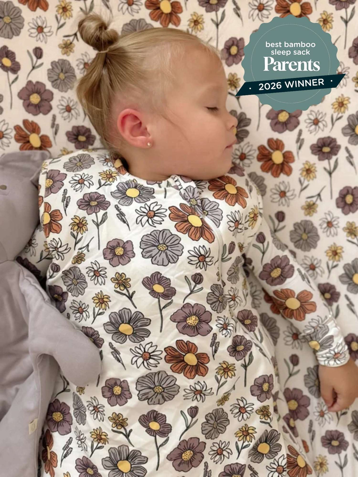 Baby in floral print sleep sack, side view, long sleeves