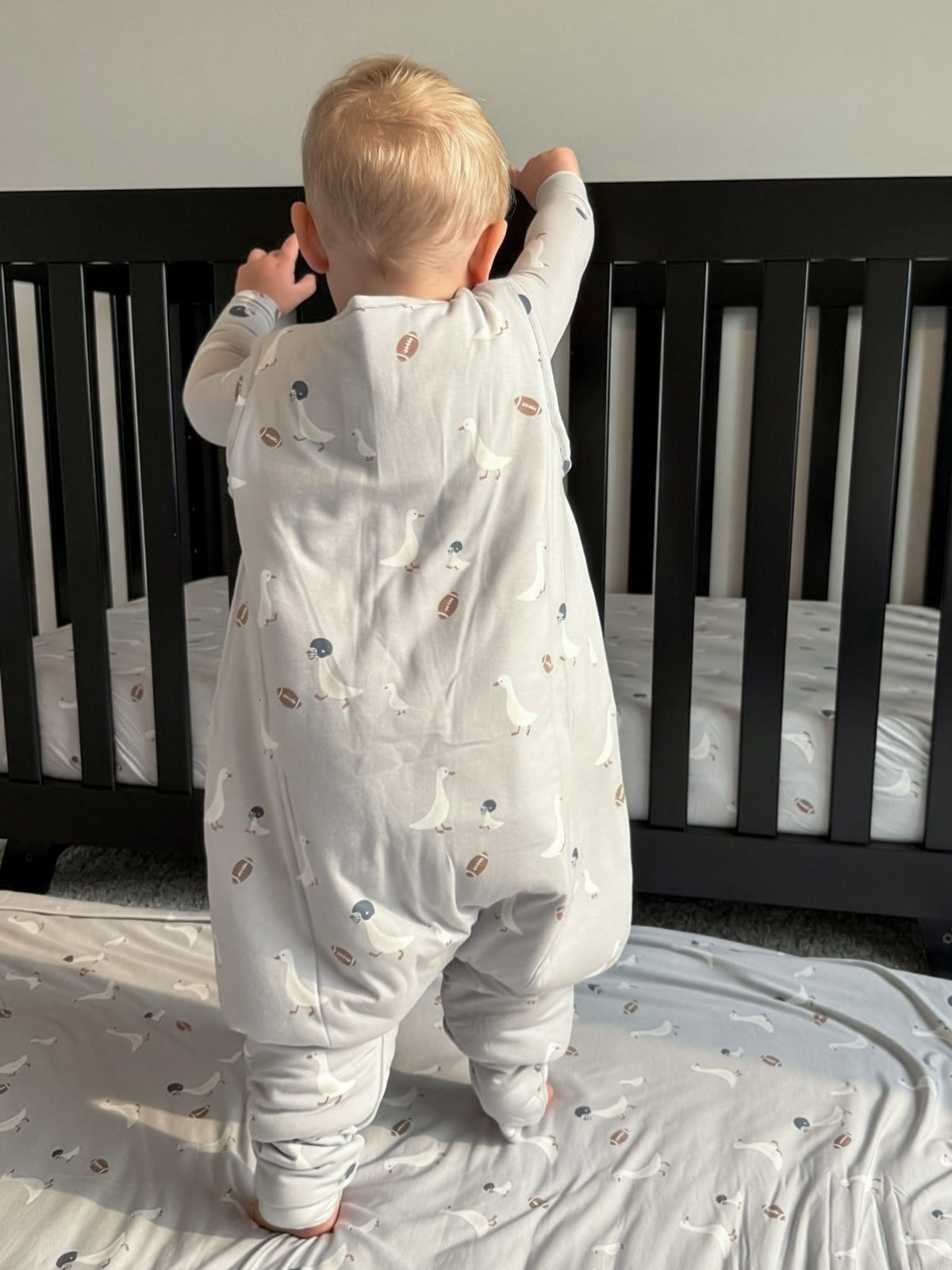 Baby footie sleep sack in light gray with football and goose prints