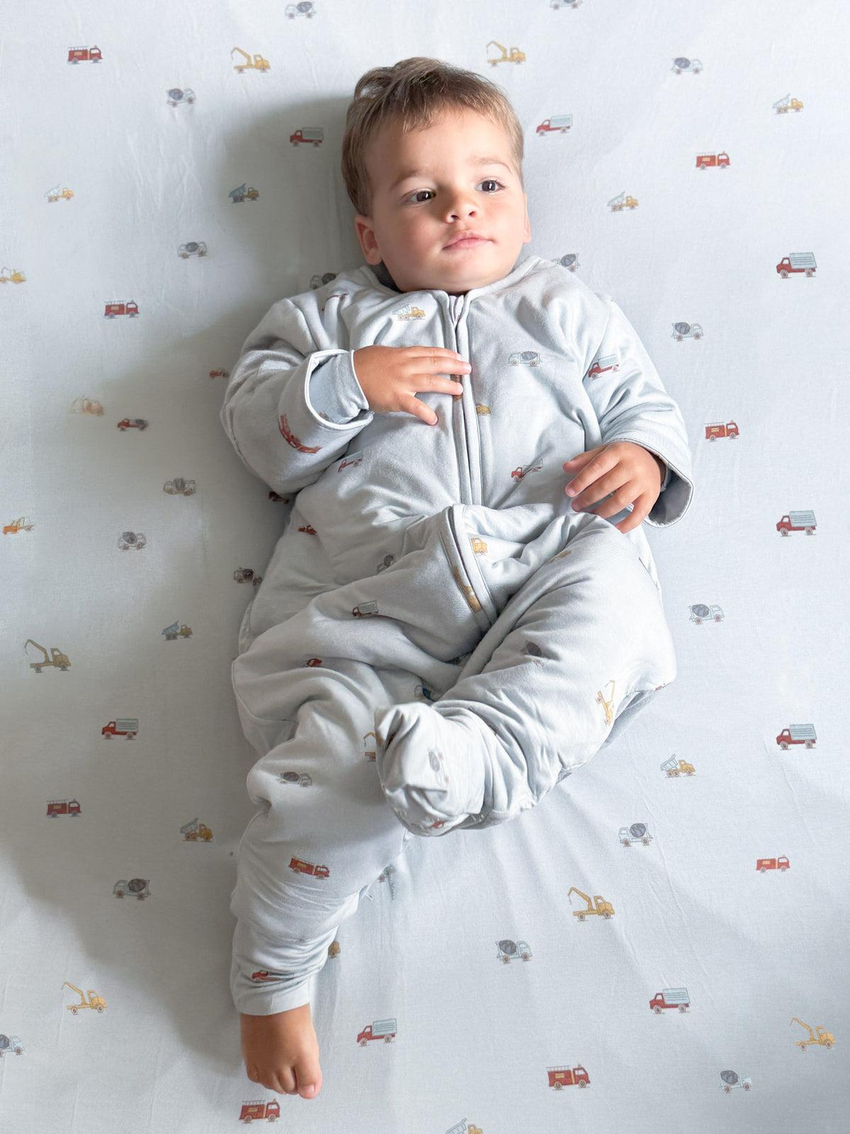 Long-sleeve footed sleep sack in light gray with small vehicle print and front zipper