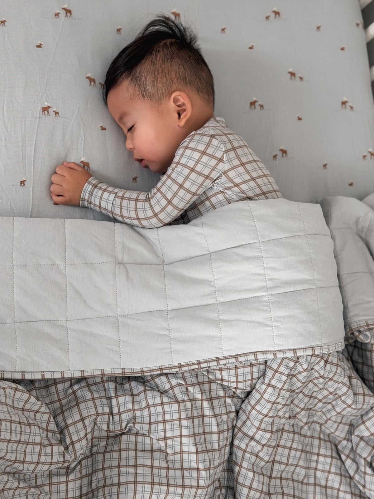 Quilted plaid baby blanket with gray-and-cream check border, folded edge