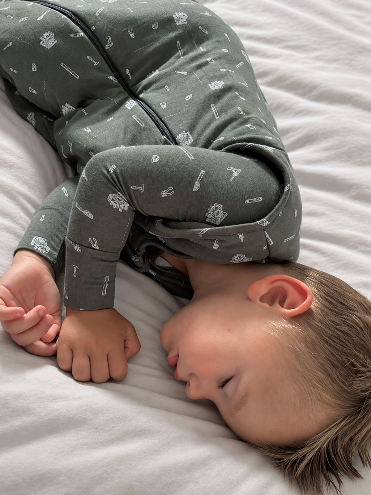 Dark gray sleep sack with white tool icons, zip-front and gathered foot opening