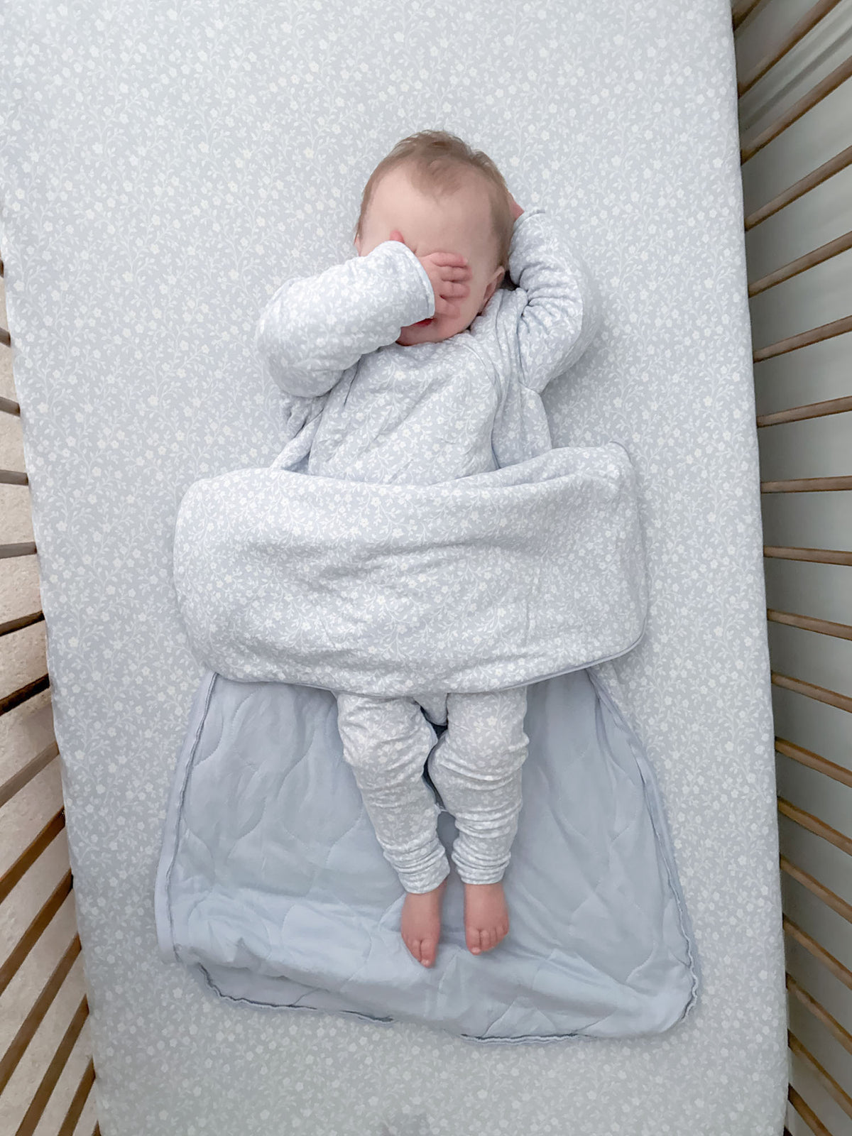 Light blue sleep sack with long sleeves, zip front, and open bottom with bare feet
