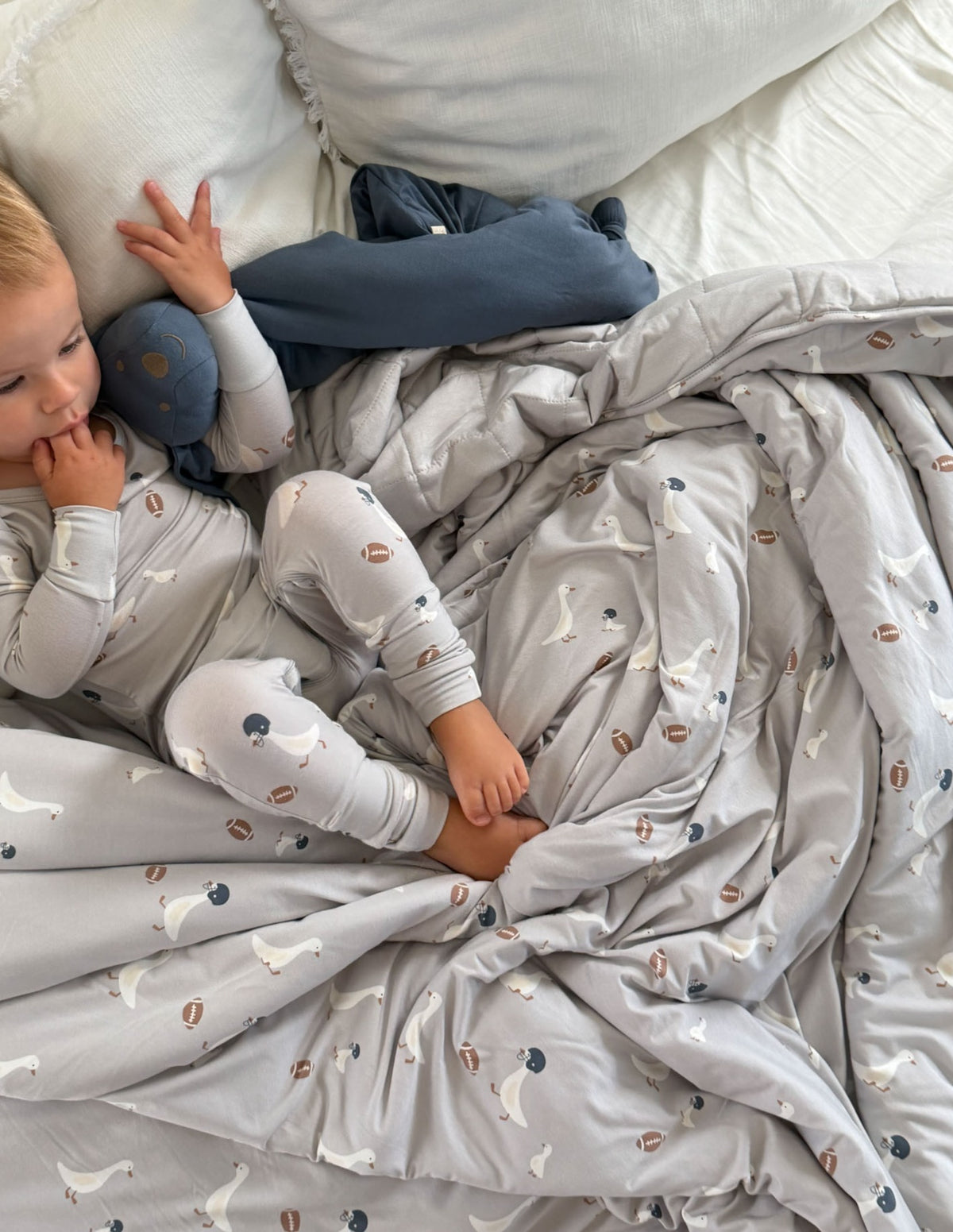 Light gray goose-print quilted baby blanket draped in folds