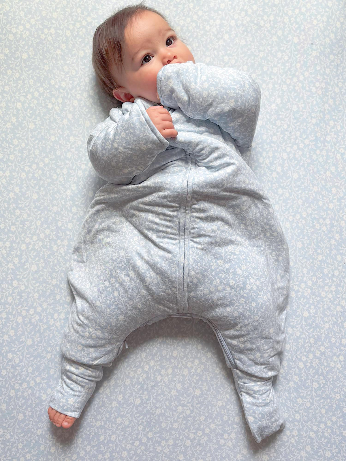 Light blue long-sleeve footie sleep sack with tiny pattern and front zipper, hand-covering cuffs
