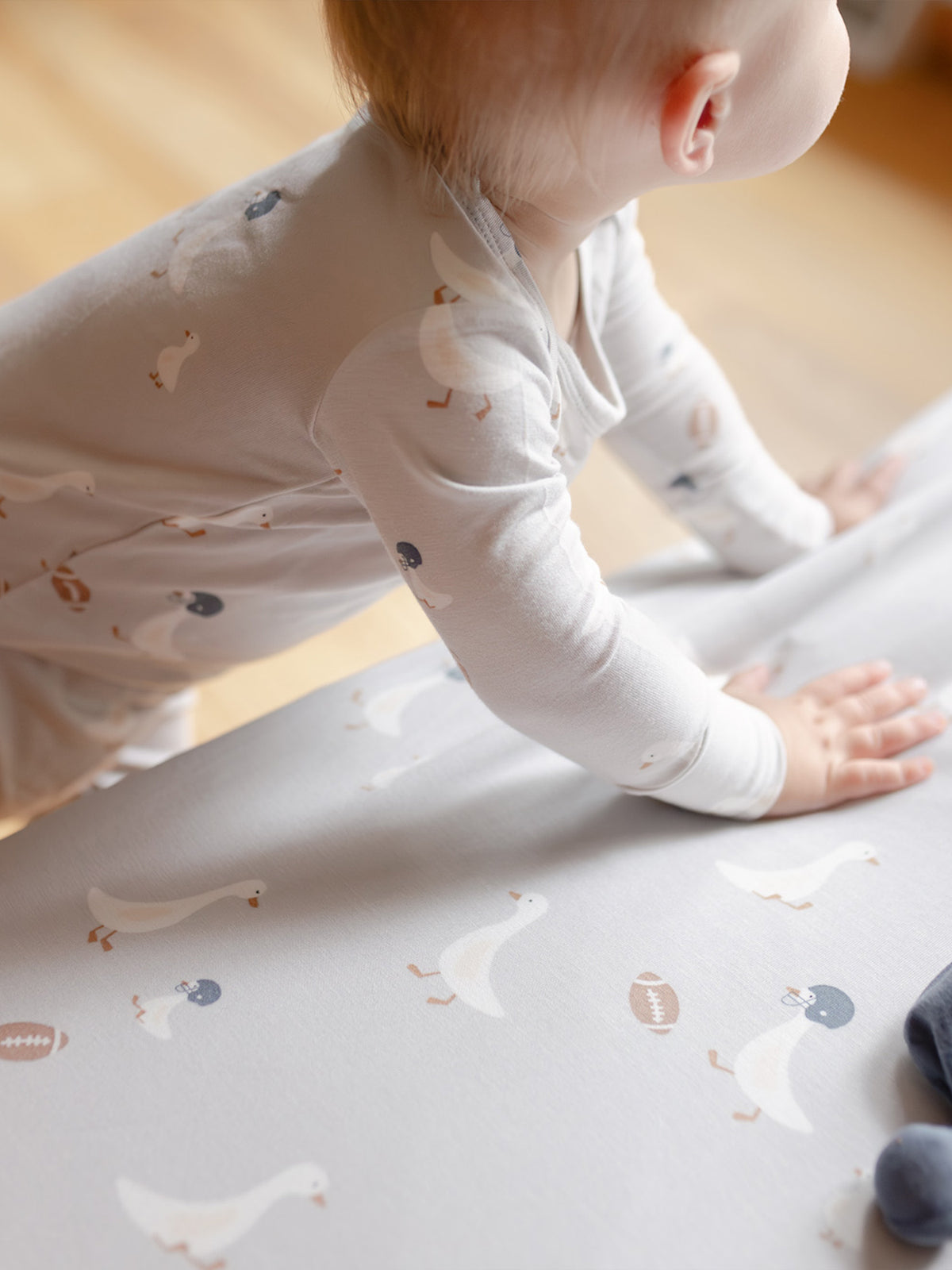 Light gray crib sheet with white goose and football print