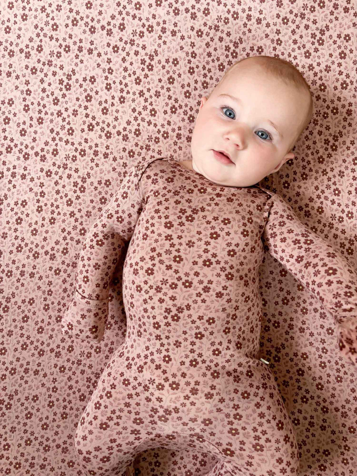 Light pink crib sheet with scattered petal flowers